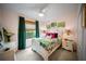 Charming bedroom with floral bedding, a large window, and soft pink walls at 2586 Wild Cherry Path, Sarasota, FL 34240