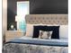 The main bedroom features a bed with luxurious pillows, a nightstand, and modern decor at 2586 Wild Cherry Path, Sarasota, FL 34240