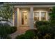 Inviting covered entry with decorative plants and exterior window views, leading to a hardwood-floored hall at 2586 Wild Cherry Path, Sarasota, FL 34240