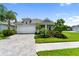 Charming single-Gathering home featuring a two-car garage, paver driveway, and lush landscaping at 2586 Wild Cherry Path, Sarasota, FL 34240