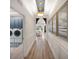 Hallway featuring modern light fixtures and views of the laundry room and living space at 2586 Wild Cherry Path, Sarasota, FL 34240