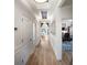 Hallway with stylish light fixtures, beautiful wood floors and decorative wall panels at 2586 Wild Cherry Path, Sarasota, FL 34240