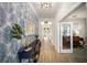 Long hallway with hardwood floors, decorative accent wall, and paneled doors at 2586 Wild Cherry Path, Sarasota, FL 34240