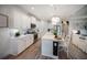 Well-lit kitchen featuring an island with seating, stainless steel appliances, and stylish cabinetry at 2586 Wild Cherry Path, Sarasota, FL 34240