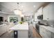 Modern kitchen featuring a large island with seating, stainless steel appliances, and decorative lighting at 2586 Wild Cherry Path, Sarasota, FL 34240