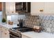 Close-up of modern kitchen showcasing designer backsplash, stainless steel appliances, and quartz countertops at 2586 Wild Cherry Path, Sarasota, FL 34240