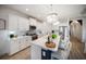 Bright kitchen features white cabinetry, stainless steel appliances, a stylish island, and modern light fixtures at 2586 Wild Cherry Path, Sarasota, FL 34240