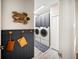 Well-designed laundry room with upper cabinets and decorative turtle wall art at 2586 Wild Cherry Path, Sarasota, FL 34240