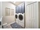 Laundry area has side-by-side washer and dryer with extra cabinet space above at 2586 Wild Cherry Path, Sarasota, FL 34240