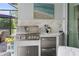 Outdoor kitchen features a built-in stainless steel grill and marble countertops at 2586 Wild Cherry Path, Sarasota, FL 34240