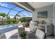A screened-in outdoor kitchen featuring a stainless steel grill and bar seating at 2586 Wild Cherry Path, Sarasota, FL 34240
