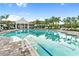 Community pool with crystal-clear water and poolside lounge chairs for relaxation at 2586 Wild Cherry Path, Sarasota, FL 34240