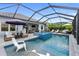 The screened-in pool area has a jacuzzi, an outdoor kitchen, and lots of room to relax at 2586 Wild Cherry Path, Sarasota, FL 34240