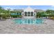 Community pool with crystal clear water, surrounded by lush landscaping, and plenty of seating at 2586 Wild Cherry Path, Sarasota, FL 34240