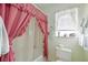 Bathroom showcasing a pink curtain shower with a window bringing light to the space at 307 Rubens Dr, Nokomis, FL 34275