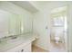 Bright bathroom with a large vanity, toilet, and doorway leading to an additional area, all in a clean, inviting space at 307 Rubens Dr, Nokomis, FL 34275