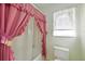Bathroom featuring a pink shower curtain, a white toilet, and a window with curtains at 307 Rubens Dr, Nokomis, FL 34275
