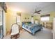 Cozy bedroom features a patterned bedspread, a ceiling fan, and large windows at 307 Rubens Dr, Nokomis, FL 34275