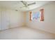 Neutral bedroom featuring a ceiling fan, window with curtains, and plush carpeting, offering a serene retreat at 307 Rubens Dr, Nokomis, FL 34275