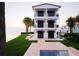 Beautiful, modern three-story home with multiple balconies overlooking a waterfront lawn at 312 Avenida Leona, Sarasota, FL 34242