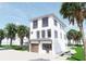 Elegant, modern home with a light gray roof, a two-car garage and mature palm trees at 312 Avenida Leona, Sarasota, FL 34242
