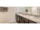 Bathroom featuring dual sinks, granite countertops, and dark wood cabinets at 3813 Willow Branch Pl, Palmetto, FL 34221