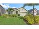 Well-maintained home with manicured lawn, complemented by tropical landscaping and a two-car garage at 3813 Willow Branch Pl, Palmetto, FL 34221
