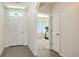 Inviting foyer with tile flooring, a bright white door, and a view into the living area at 3813 Willow Branch Pl, Palmetto, FL 34221