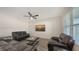 Cozy living room with dark wood floors, a ceiling fan, and comfortable leather seating at 3813 Willow Branch Pl, Palmetto, FL 34221
