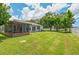 Expansive backyard with green lawn and partial view of the home and screened porch at 4214 38Th W St, Bradenton, FL 34205