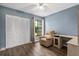 Bedroom with hardwood floors, blue walls, a ceiling fan, a recliner, and an expansive closet space at 4214 38Th W St, Bradenton, FL 34205
