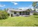 Spacious and relaxing backyard with screened porch, dining area, and lush greenery at 4250 Winfall Ave, North Port, FL 34286