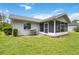 Lush backyard with green outdoor dining and seating space with screened porch at 4250 Winfall Ave, North Port, FL 34286