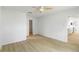 Bedroom featuring light wood floors, a ceiling fan, and access to an ensuite bathroom and closet at 4250 Winfall Ave, North Port, FL 34286