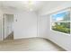 Bright bedroom featuring a modern light fixture, light wood floors, and a large window at 4250 Winfall Ave, North Port, FL 34286