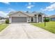 Well-maintained home with an attached garage and long driveway, complemented by a manicured lawn at 4250 Winfall Ave, North Port, FL 34286