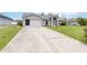 A charming home featuring a long driveway and well-kept lawn, and an attached garage at 4250 Winfall Ave, North Port, FL 34286