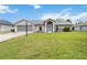 Charming single-story home featuring a well-manicured lawn, attached garage, and welcoming screened front entry at 4250 Winfall Ave, North Port, FL 34286