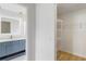 Hallway featuring access to an ensuite bathroom with blue cabinets and a walk-in closet with shelving at 4250 Winfall Ave, North Port, FL 34286