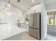 Bright kitchen showcasing white cabinets, stainless steel appliances, and an adjacent sliding glass door to the patio at 4250 Winfall Ave, North Port, FL 34286