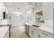 Bright kitchen featuring white cabinets, gold hardware, stainless steel appliances, and a light wood floor at 4250 Winfall Ave, North Port, FL 34286