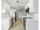 Sleek modern kitchen featuring white cabinets, stainless steel appliances, and stylish gold hardware accents at 4250 Winfall Ave, North Port, FL 34286