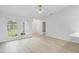 Spacious living room with light wood-look floors, ceiling fan, and large windows allowing for ample natural light at 4250 Winfall Ave, North Port, FL 34286