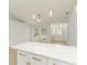 Bright living room with modern light fixture and an island with white cabinets and gold hardware at 4250 Winfall Ave, North Port, FL 34286
