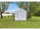 Outdoor storage shed featuring a neutral paint color with a spacious green yard at 4250 Winfall Ave, North Port, FL 34286