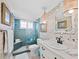 Stylish bathroom features a glass shower, ornate mirror, and floral wallpaper at 4420 Exeter Dr # 303, Longboat Key, FL 34228
