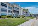 Attractive condo building with lush landscaping and a clear blue sky at 4420 Exeter Dr # 303, Longboat Key, FL 34228