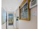 Hallway with tiled floor and artwork of a beach scene, leading to the front door at 4420 Exeter Dr # 303, Longboat Key, FL 34228