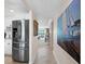 Hallway with stainless steel refrigerator leading to a dining area with bright view of the water at 4420 Exeter Dr # 303, Longboat Key, FL 34228