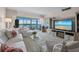 Bright living room with white sofa set, fireplace, TV, and scenic water view at 4420 Exeter Dr # 303, Longboat Key, FL 34228